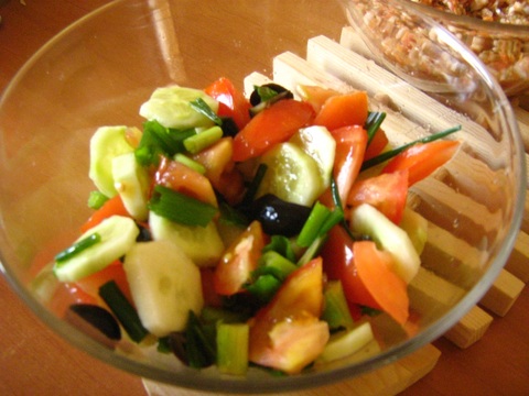 Fresh salad from tomatoes, cucumber, onion, olives and a squeeze of a lemon